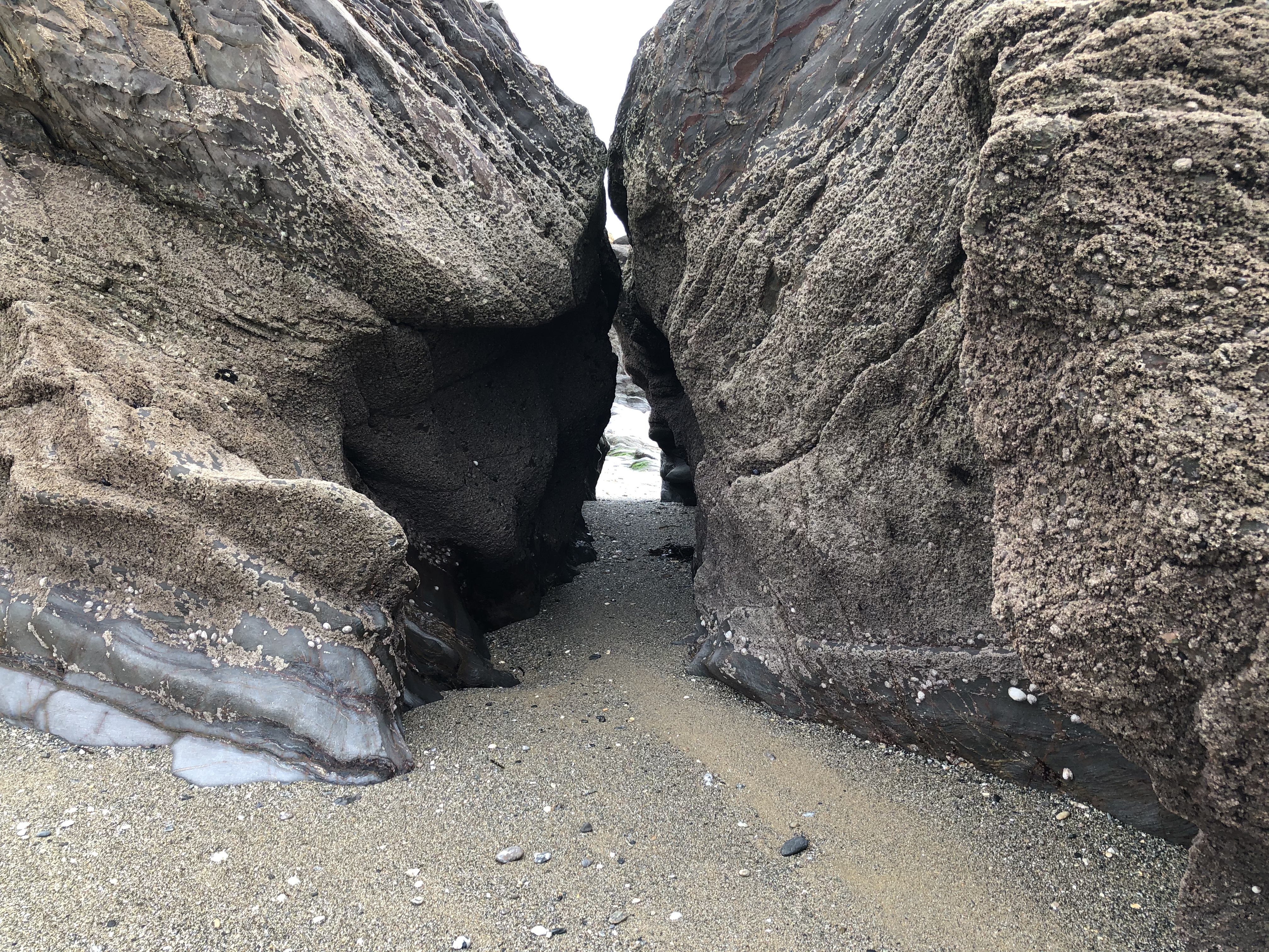 Cornwall with kids: Hemmick Beach - view through crack in two large rocks
