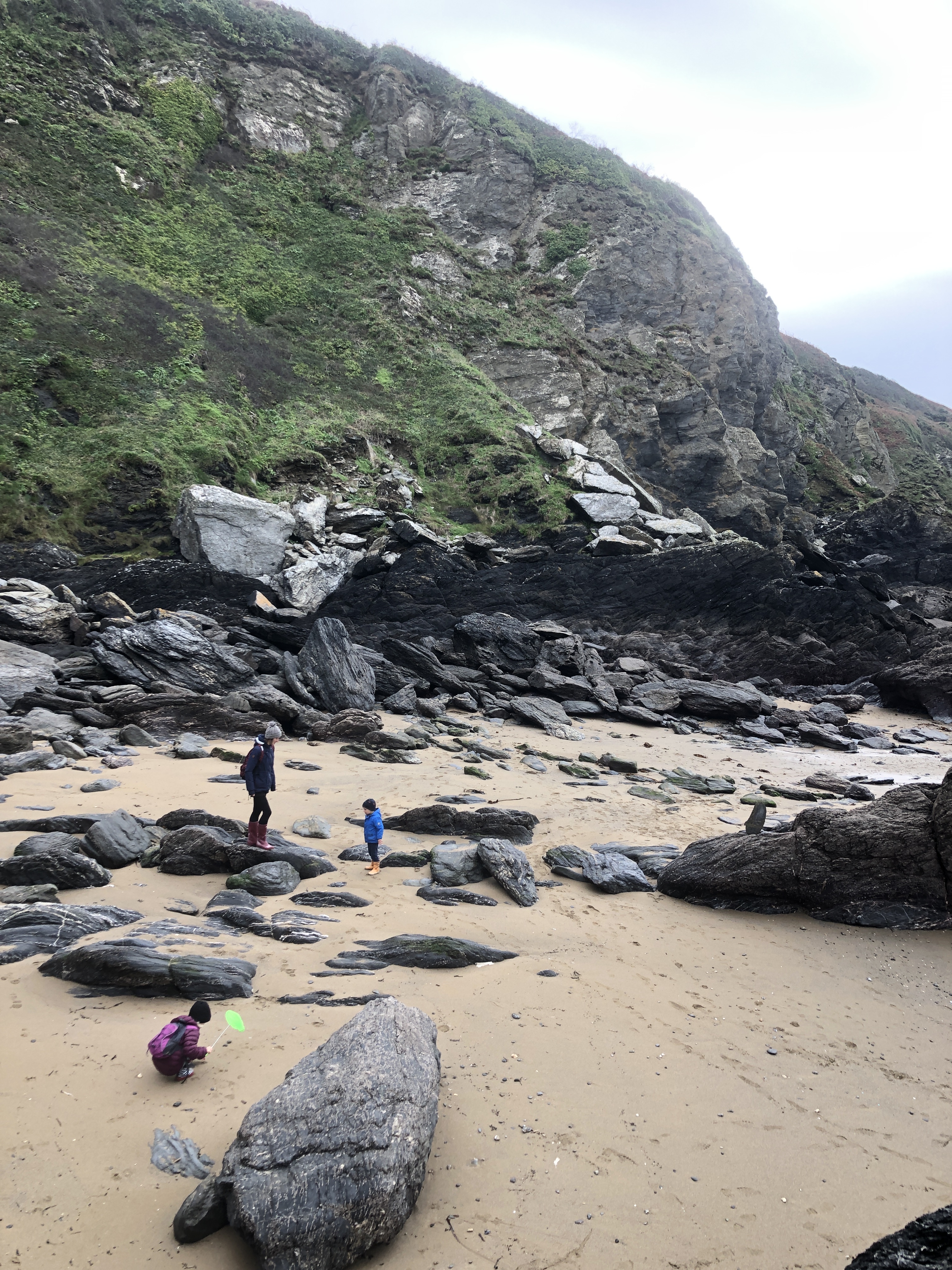 Cornwall with kids: Hemmick Beach - mum and two children exploring rocks on beach