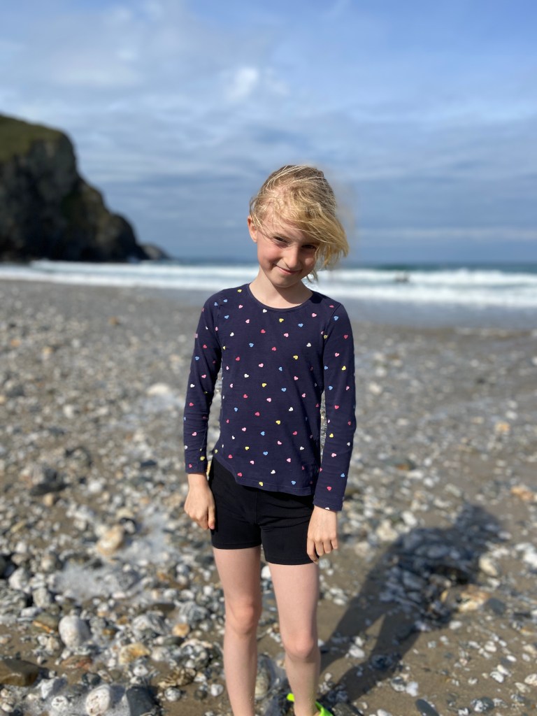 My 9 year old daughter smiling for a portrait photo at Porthtowan beach in Cornwall