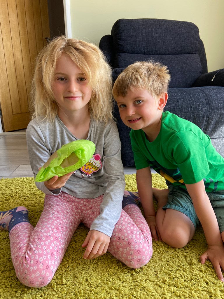 siblings smiling for the camera holding a birthday present