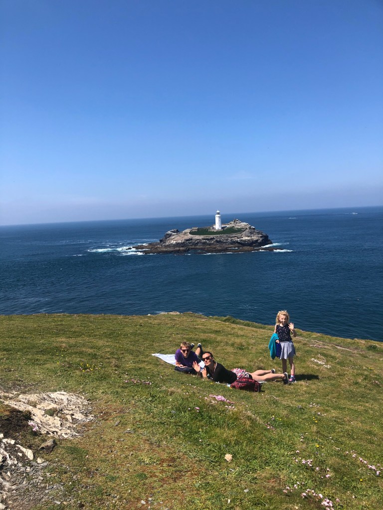 Sunbathing on the cliffs near Godrevy lighthouse in Cornwall