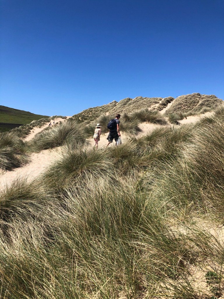 walking up sand dunes Holywell beach near newquay cornwall