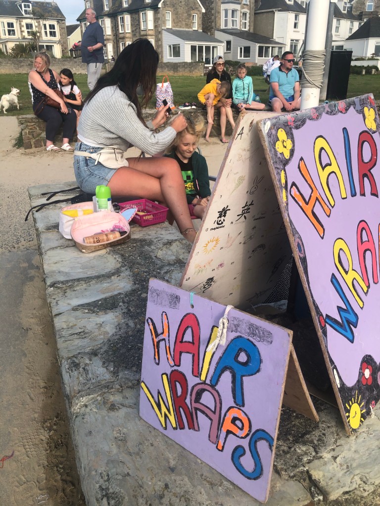 Girl having hair wrap in Perranporth in Cornwall