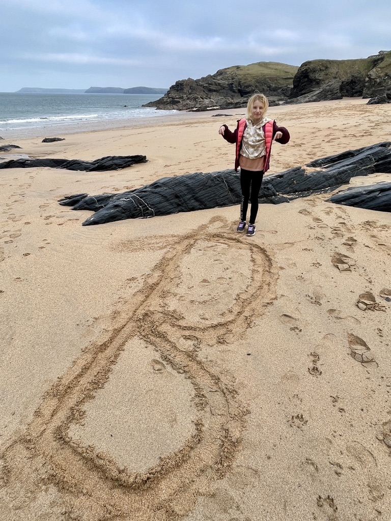 writing initial in sand mother iveys bay cornwall padstow