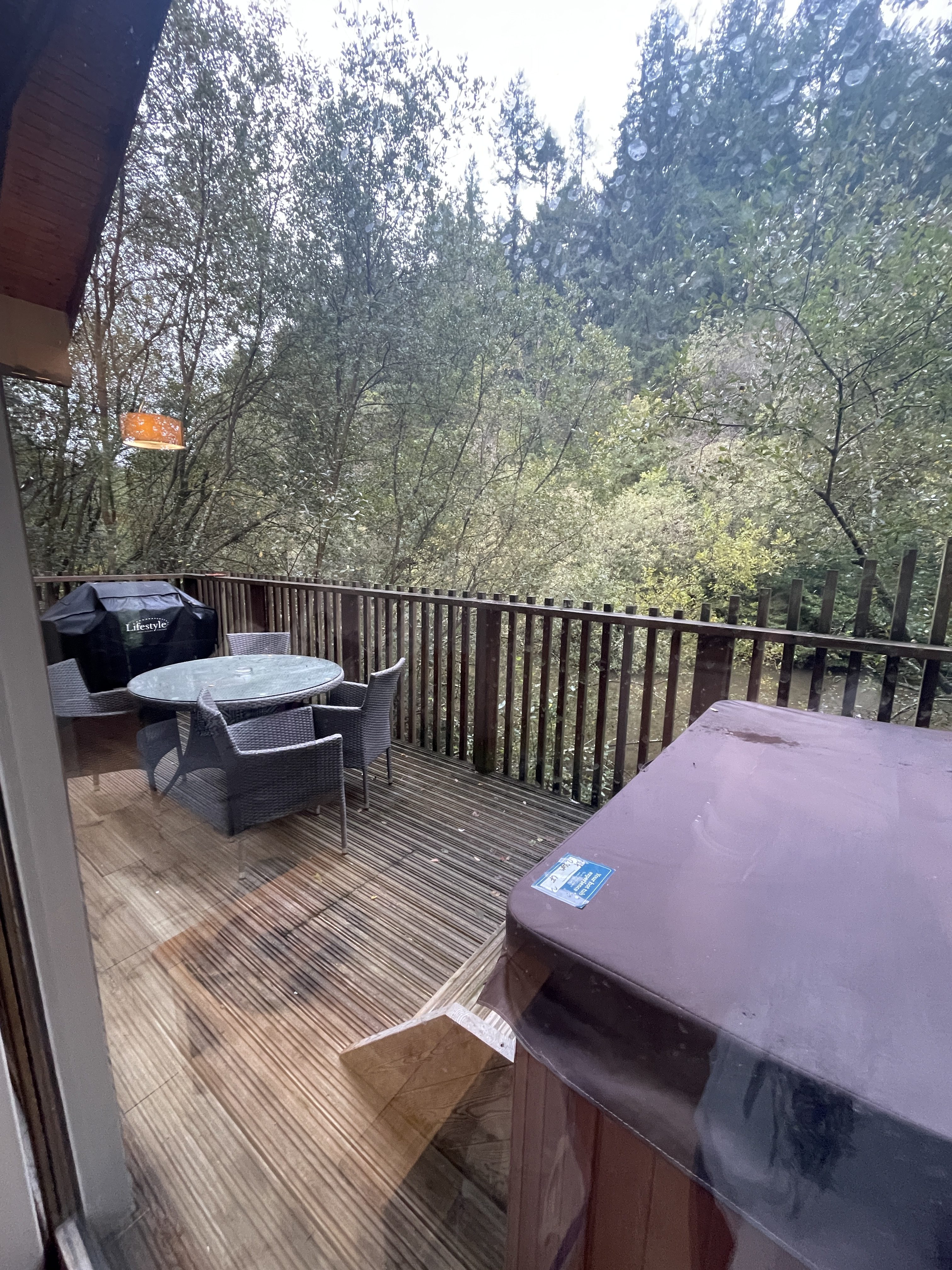 Outside dining area and BBQ on the deck at deerpark forest holidays woodland lodge in cornwall