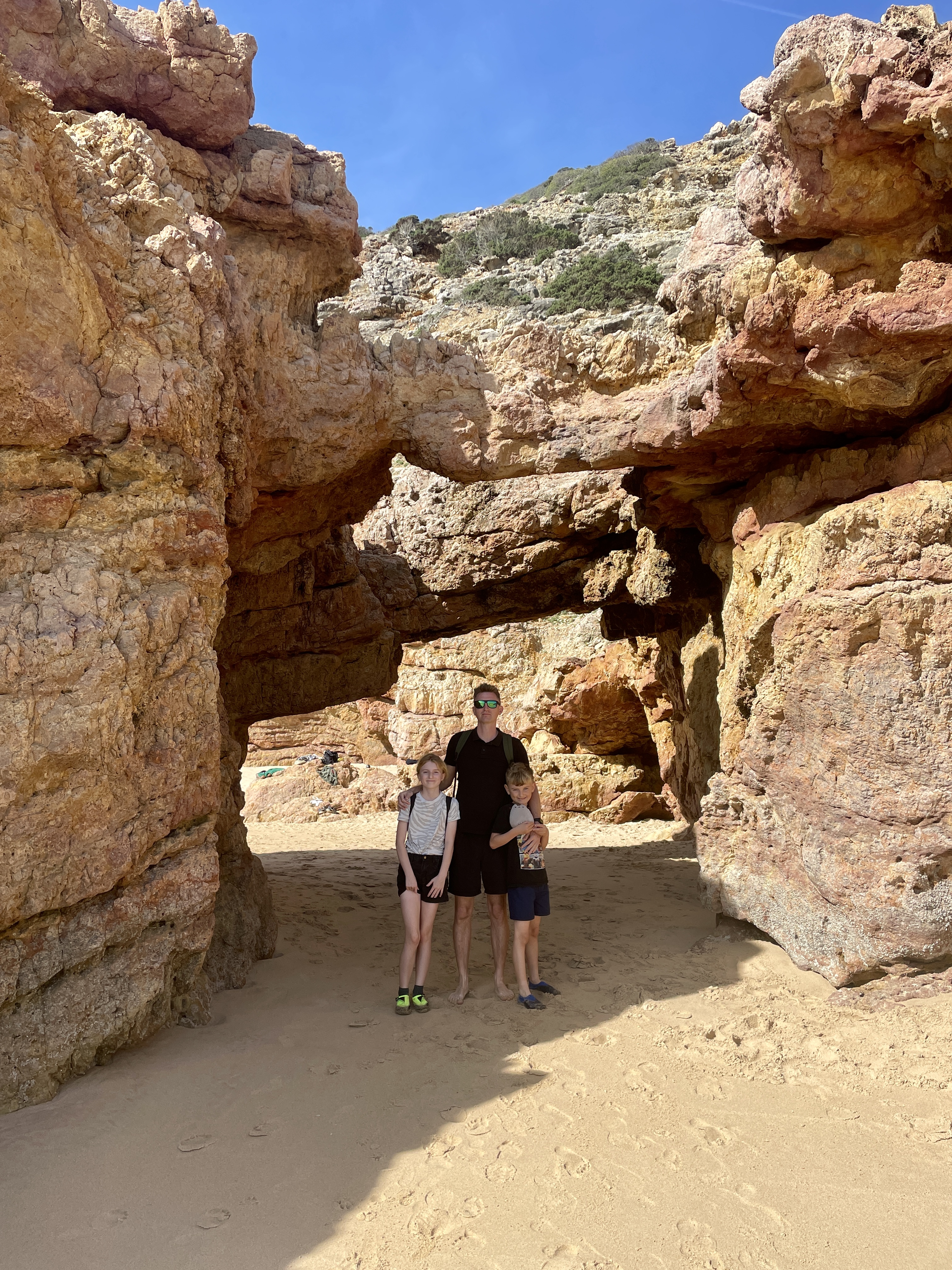 Natural cave formations along the cliffside at Praia da Andorinha