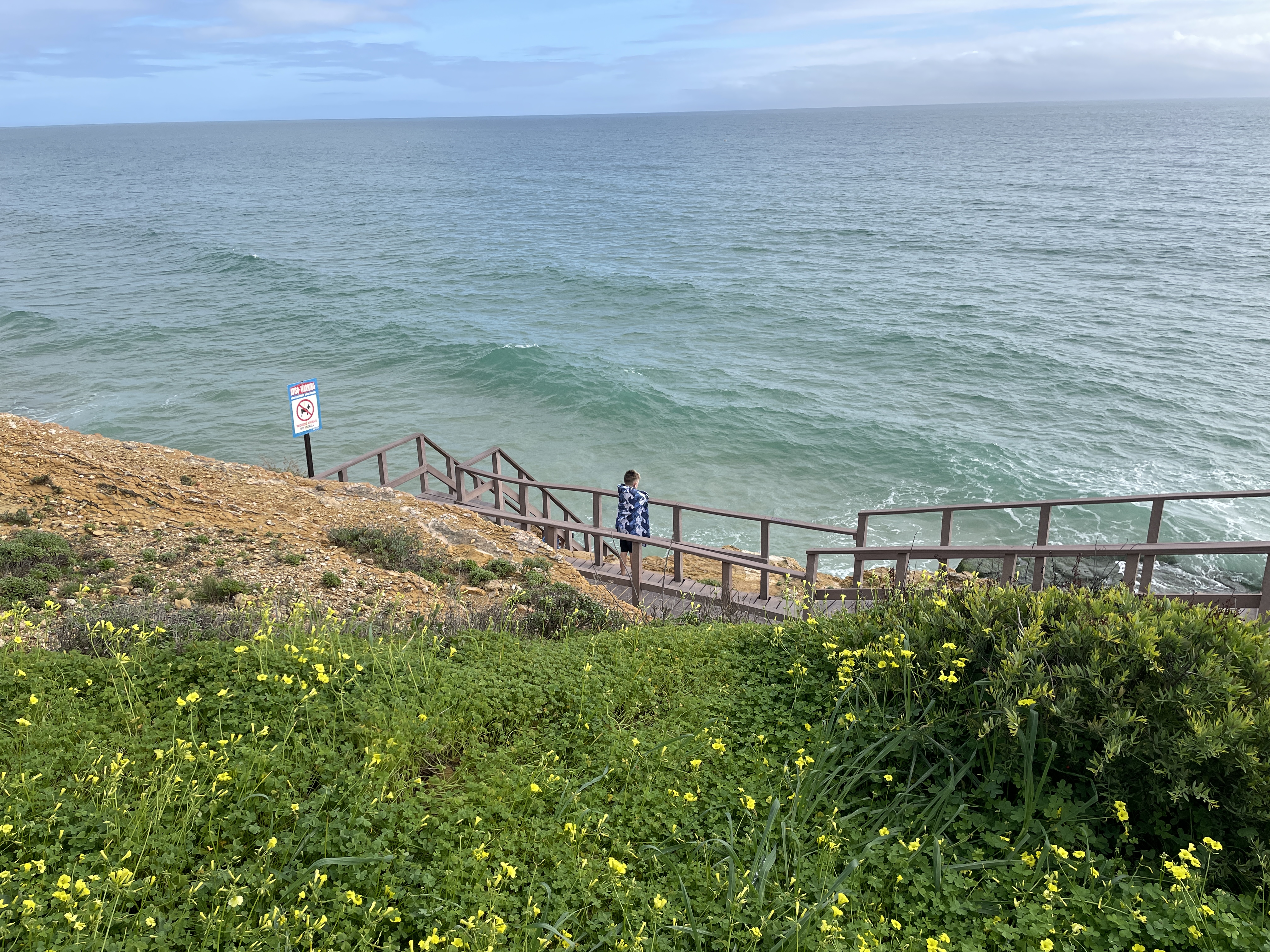 Wave watching at high tide at Salema Beach