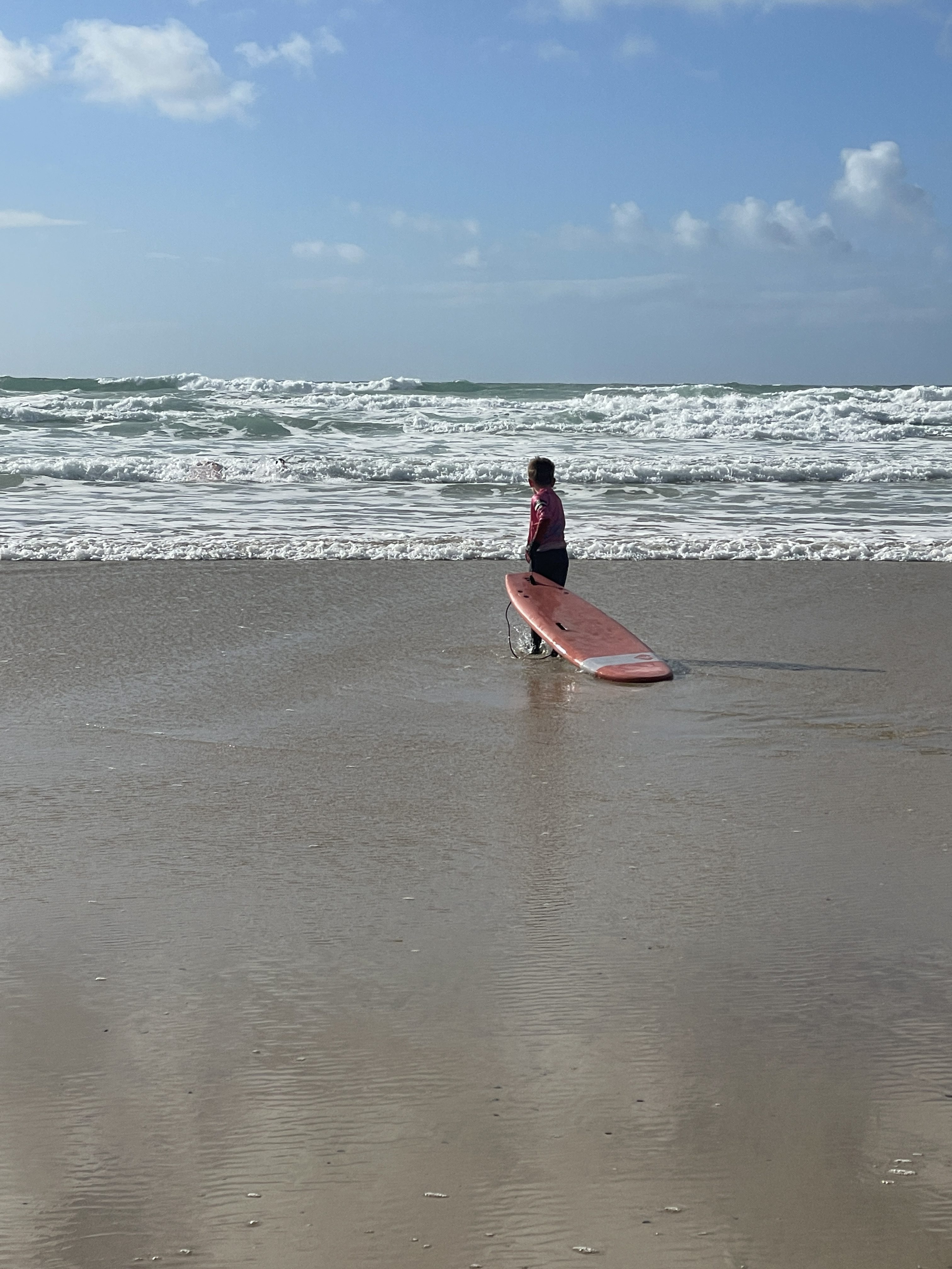 child having a surf lesson at fistral beach in newquay cornwall
