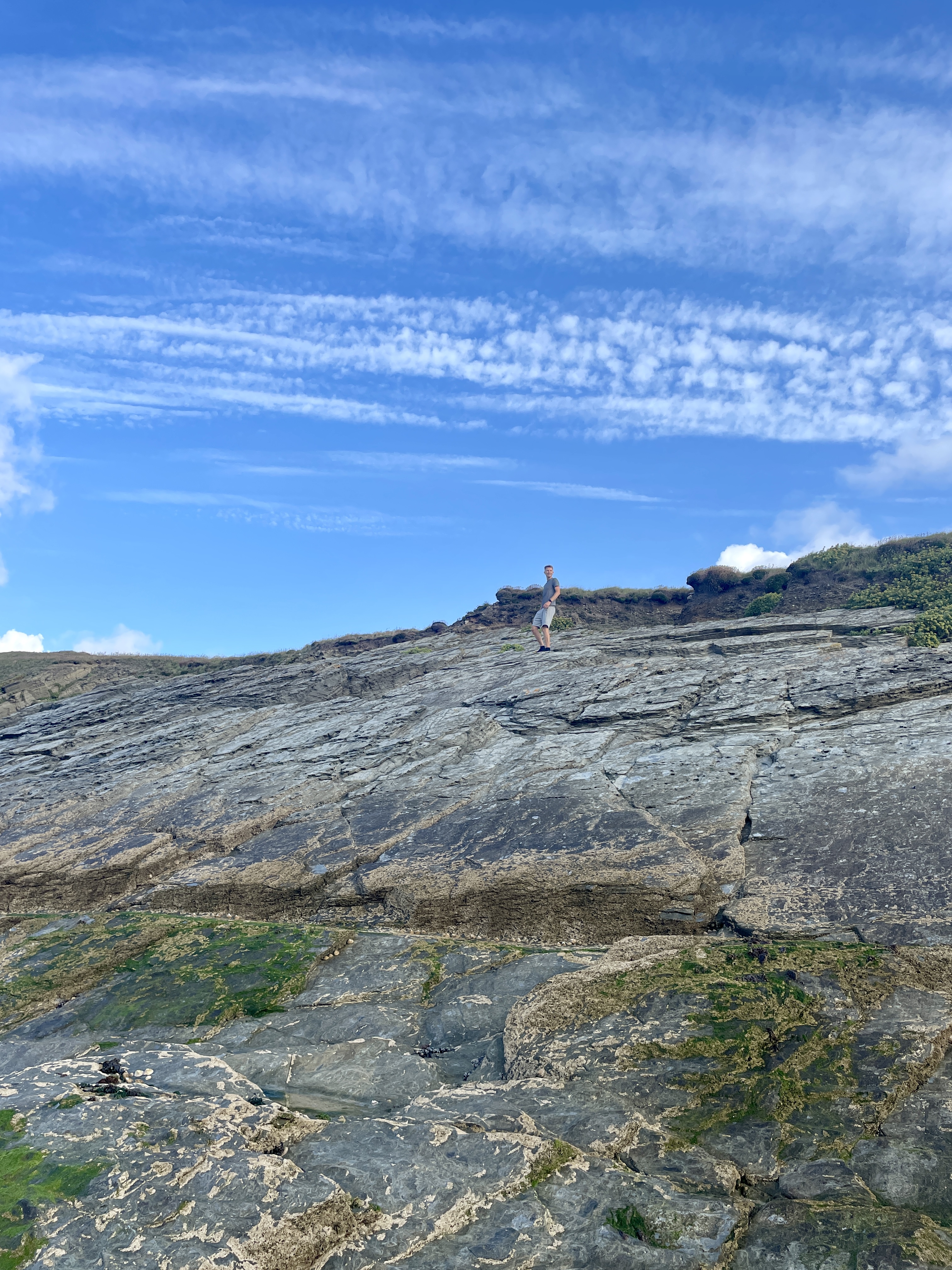 My husband and I climbing the rocks to reach Trevelgue Headland from Porth Beach