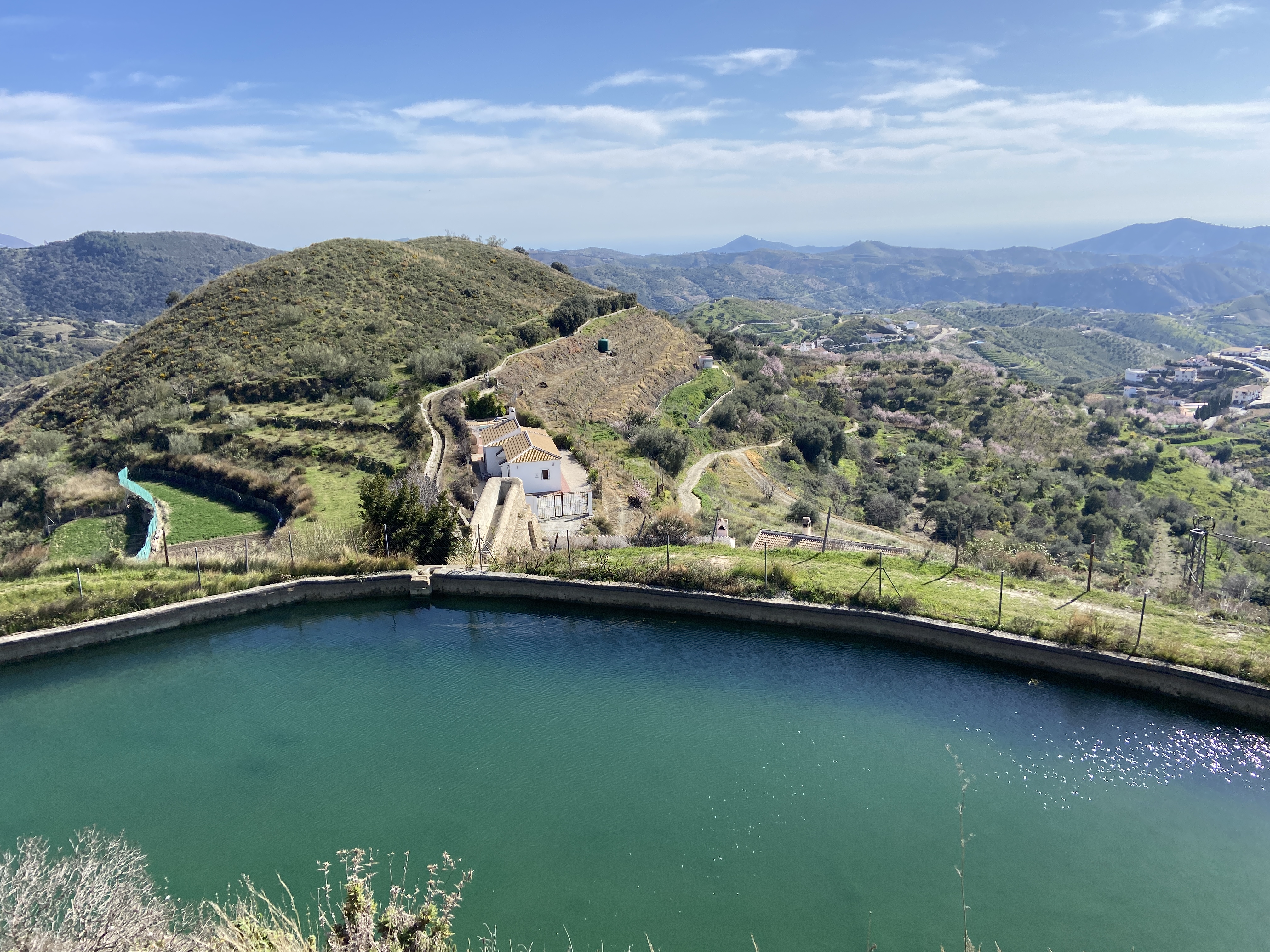 reservoir of water near sedella in spain with mountain views behind