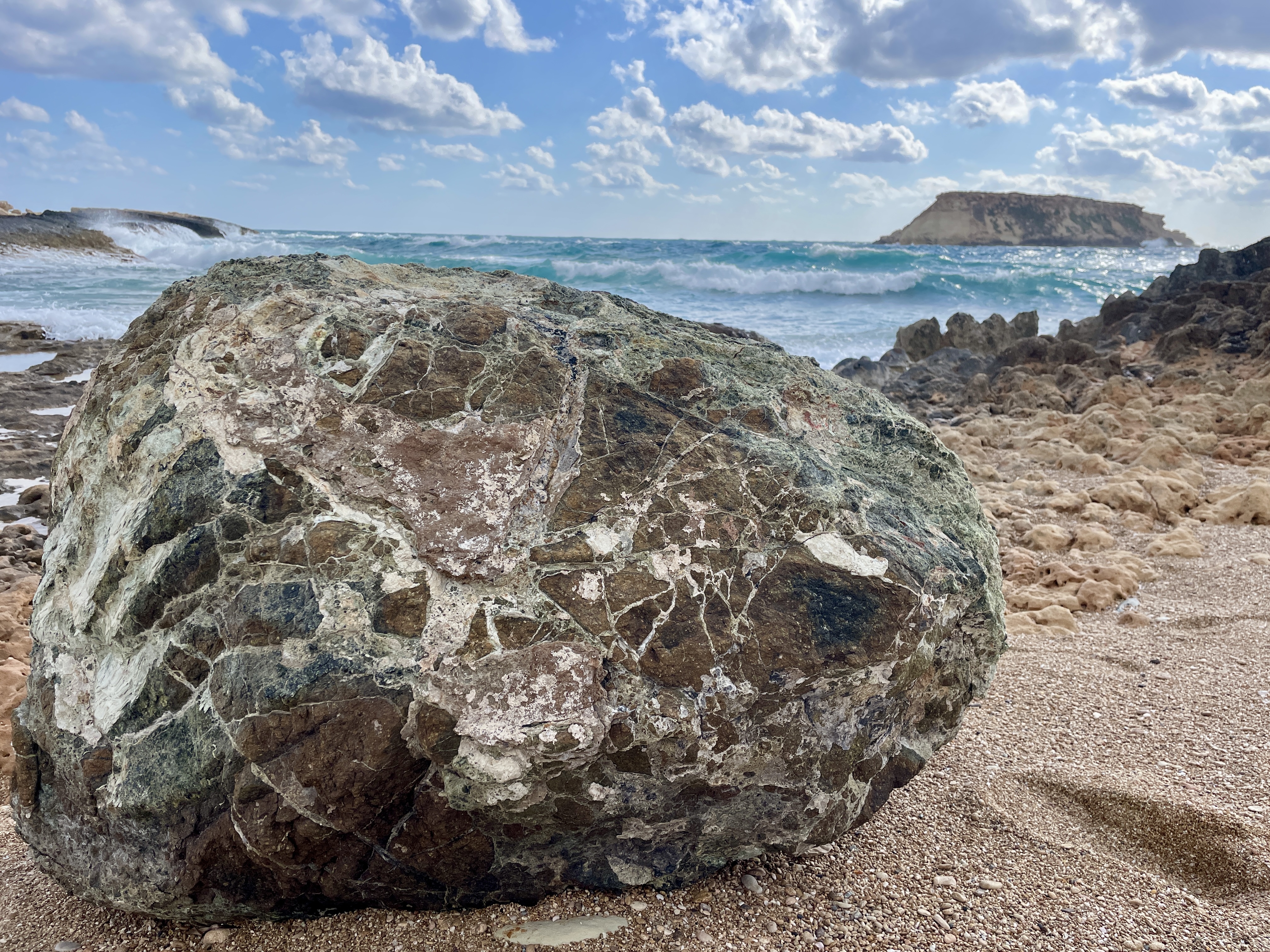Large sea battered boulder and view of Geronisos Island