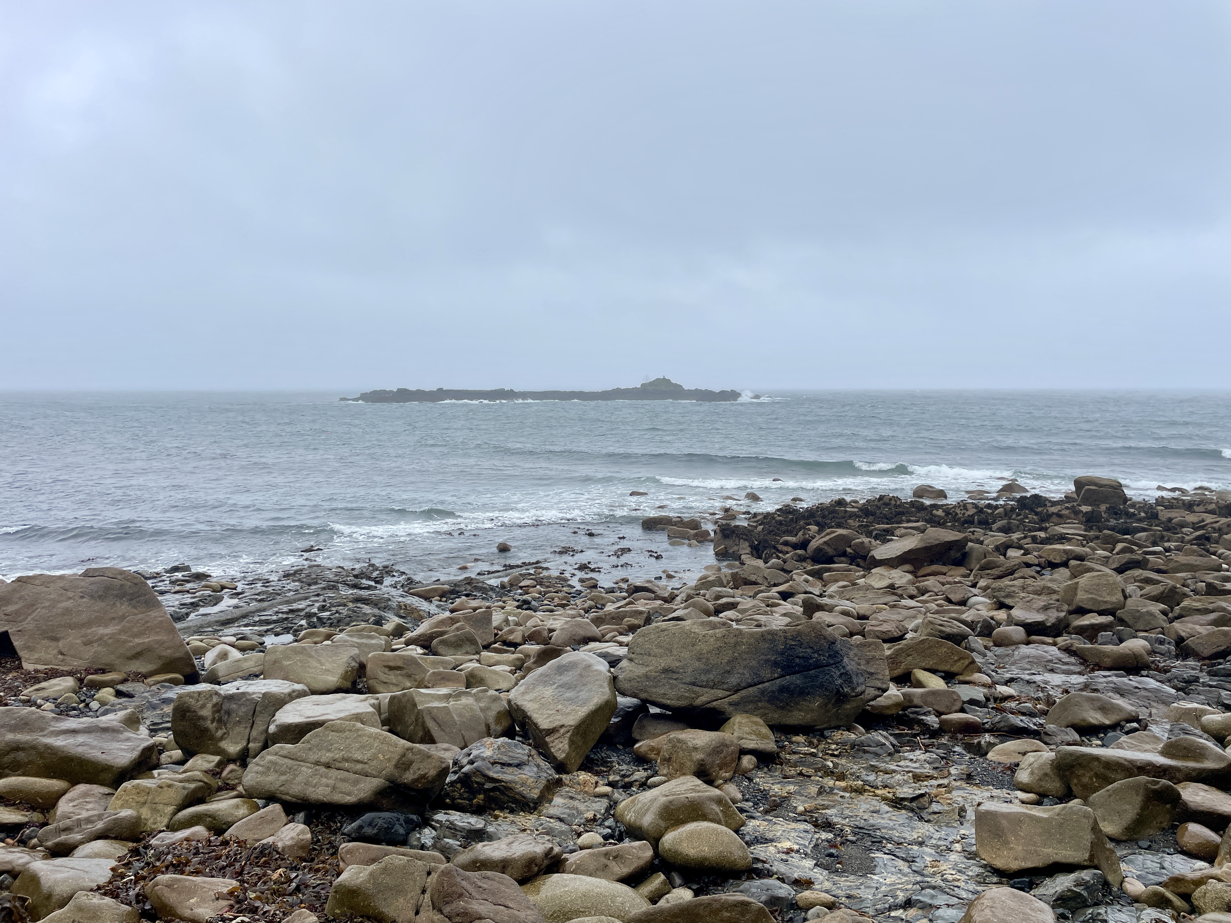 St clement's isle just visible on a rainy day in mousehole