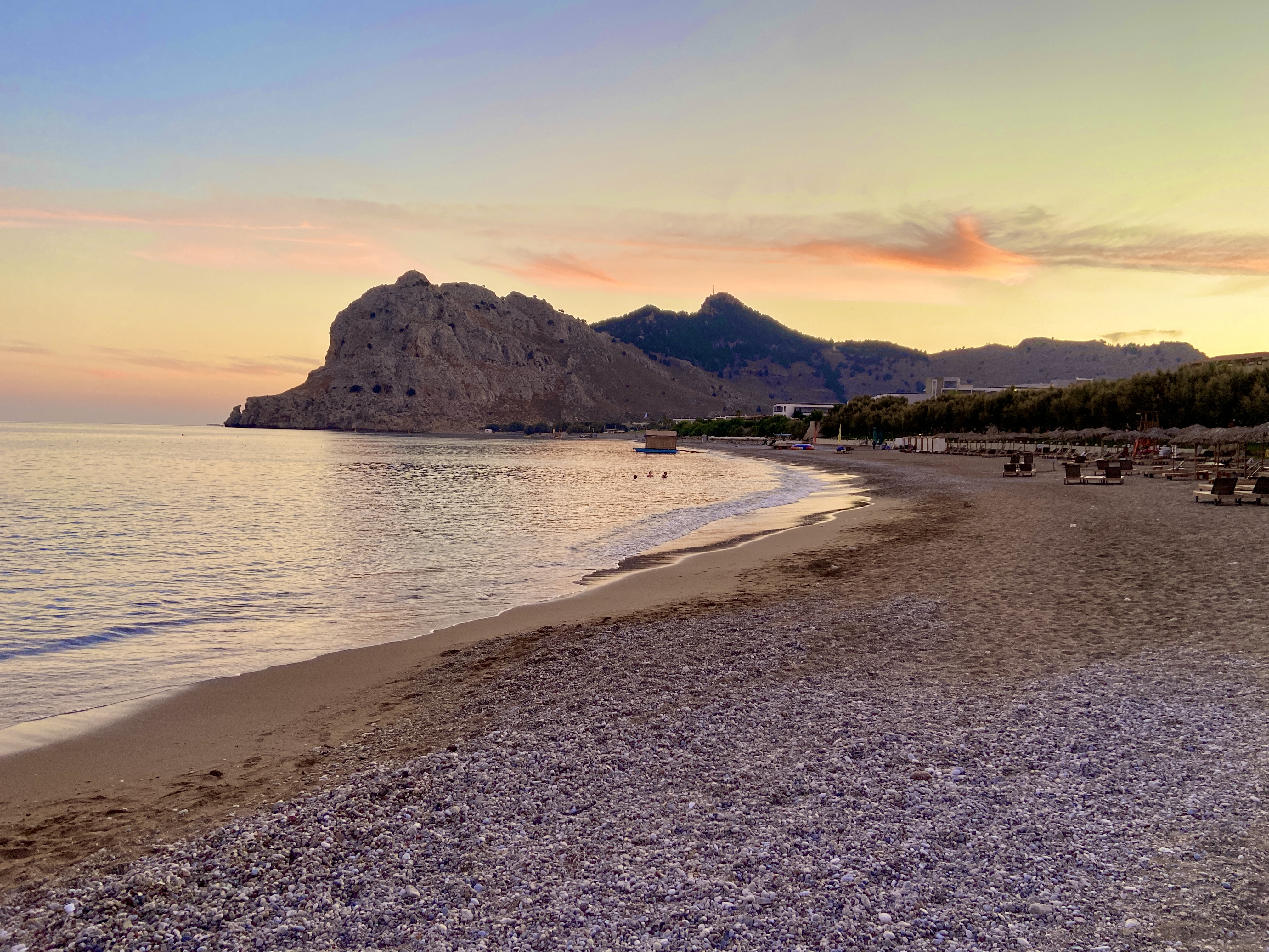 Evening sunset stroll along Kolymbia Beach in Rhodes with Tsambika Mountain in the background