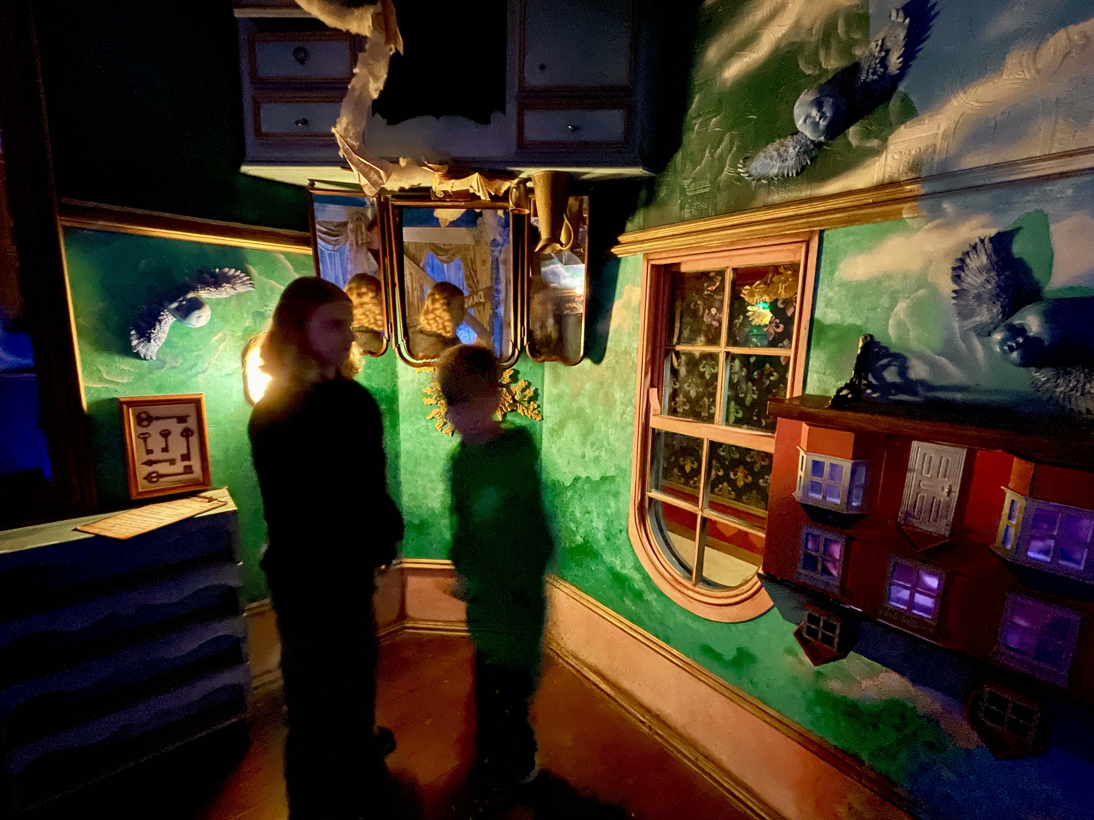 Children exploring the upside down room with green painted walls at Wake the Tiger Bristol