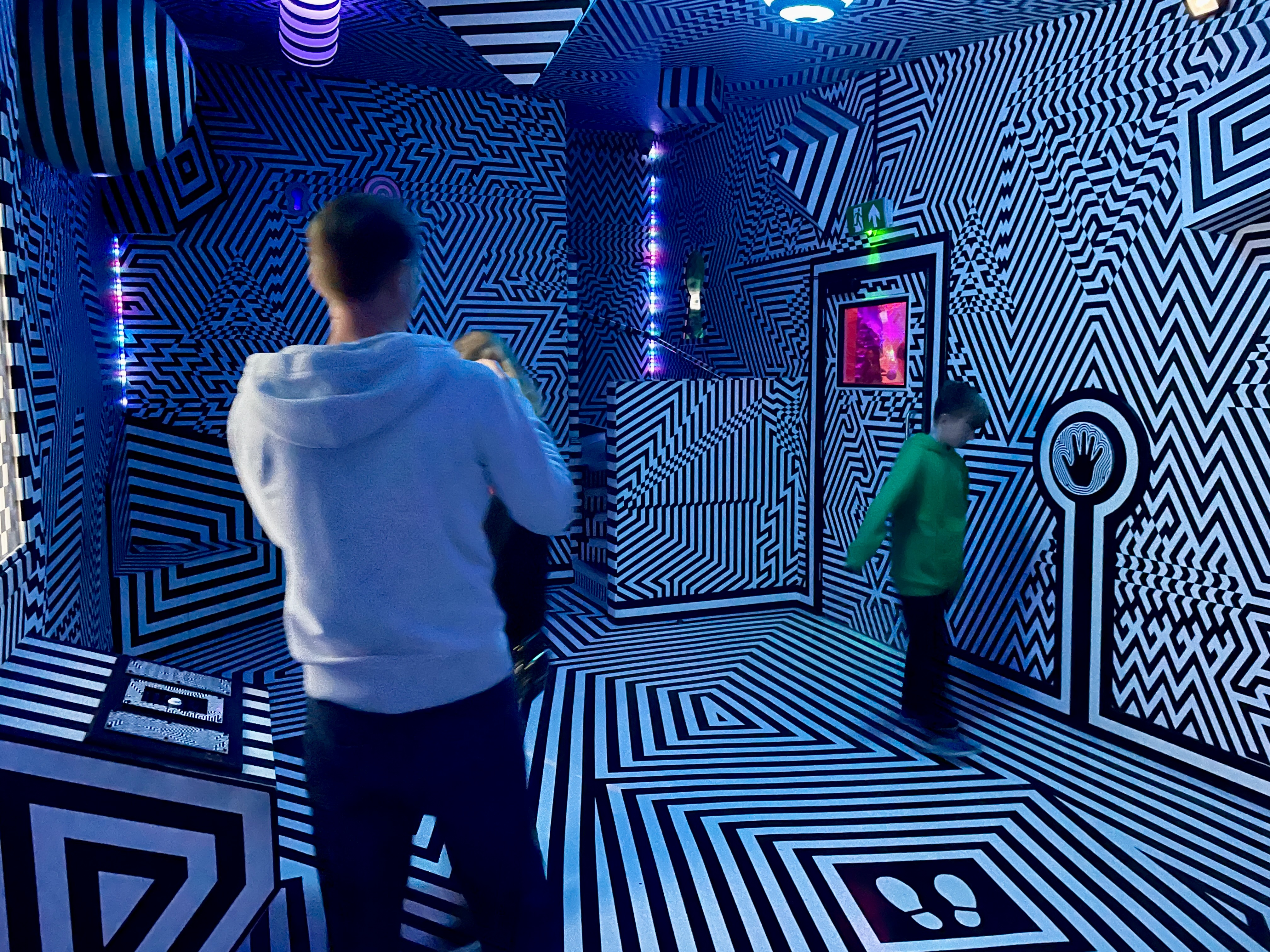 Visitors in the black and white geometric optical art room at Wake the Tiger Bristol