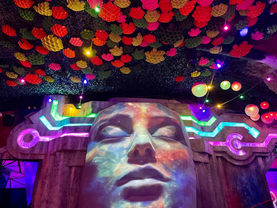 Giant projected female face with multicoloured cluster ceiling at Wake the Tiger Bristol