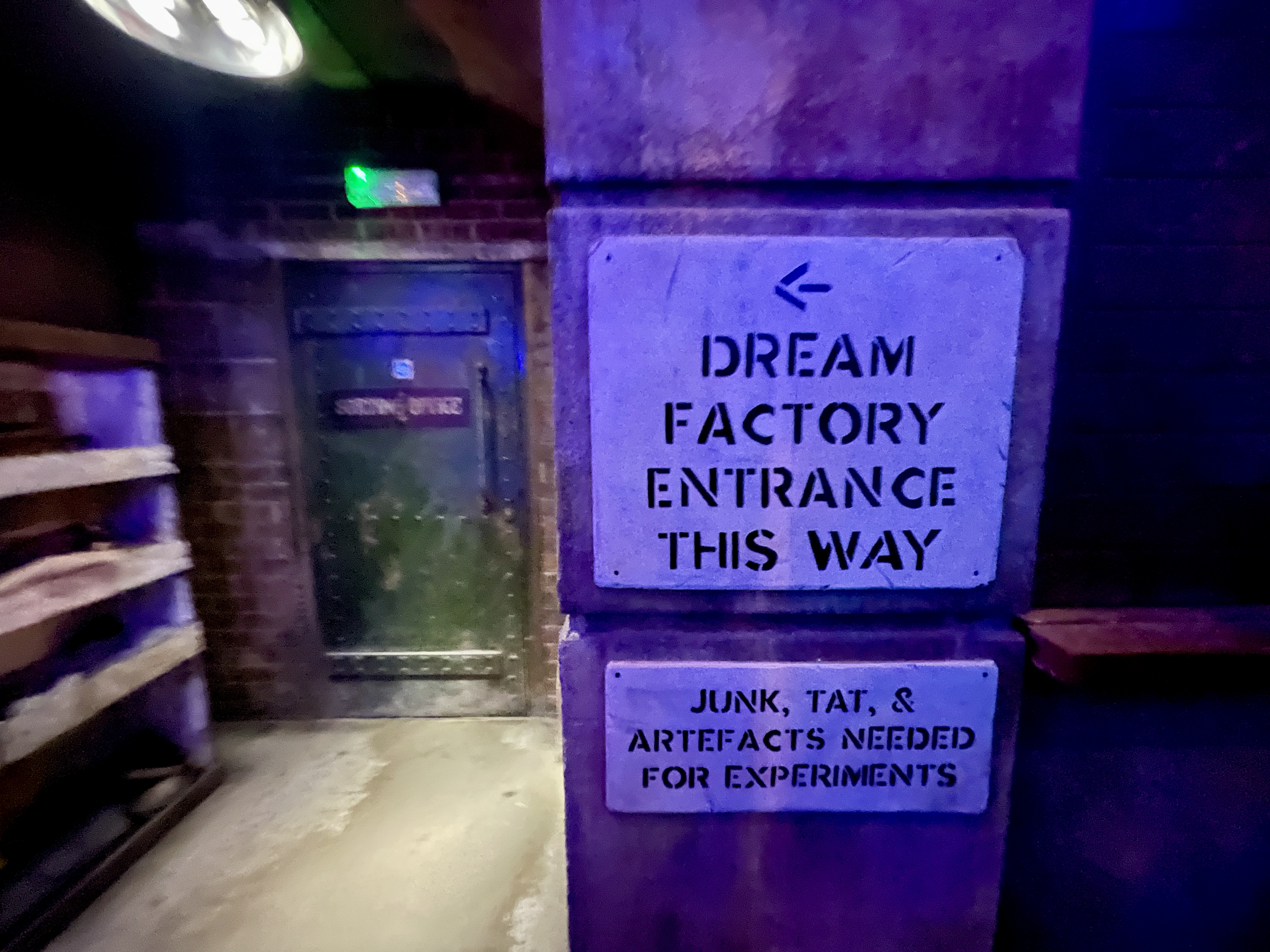 Dream Factory Entrance This Way sign with junk tat and artefacts notice at Wake the Tiger Bristol